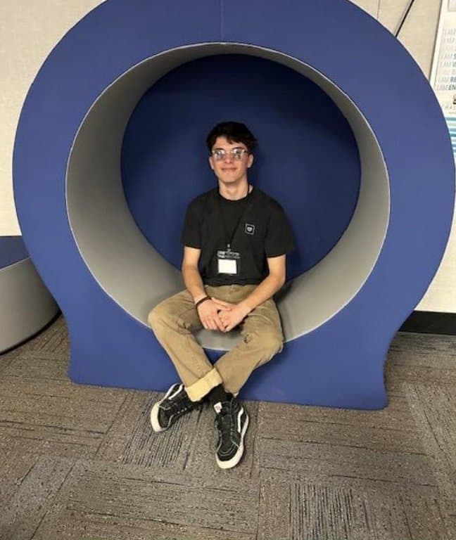 A student relaxing in the Wellness Center's round alcove seat.