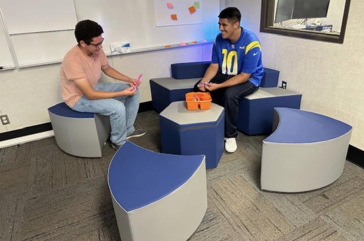 Two students talking on the Wellness Center's soft seating.